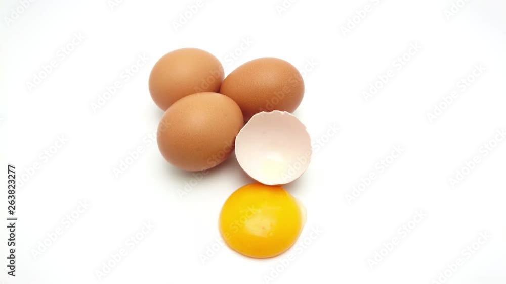 Slide shot of Whole eggs with cracked egg showing yolk isolated on white background Slide shot of Whole eggs with cracked egg showing yolk isolated on white background