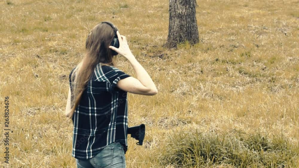 View behind a woman adjusting ear protection on a rifle range, 29fps. View behind a woman adjusting ear protection on a rifle range, 29fps.