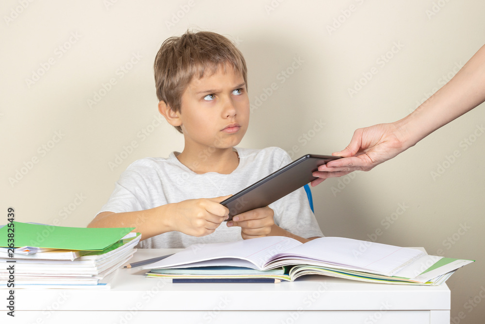 Video games addiction. Mother taking tablet away from the kid hands Video games addiction. Mother taking tablet away from the kid hands