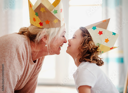 Foto A portrait of small girl with grandmother at home, having fun.