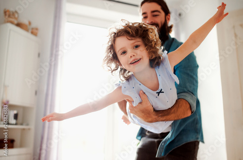 Small girl with young father in bathroom at home, having fun. photo