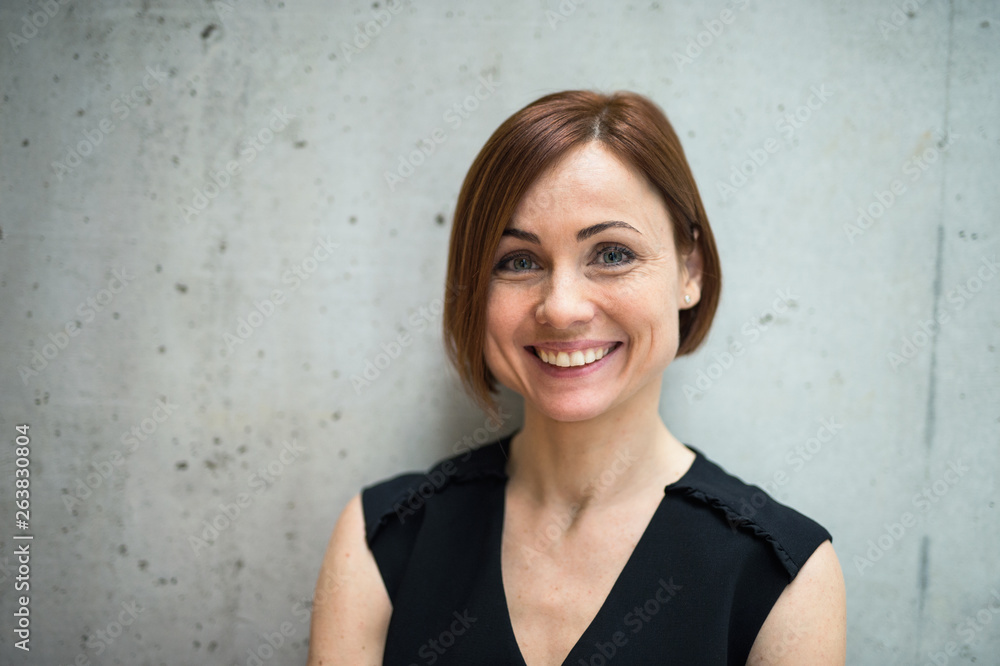 A portrait of young businesswoman standing in office, looking at camera. A portrait of young businesswoman standing in office, looking at camera.