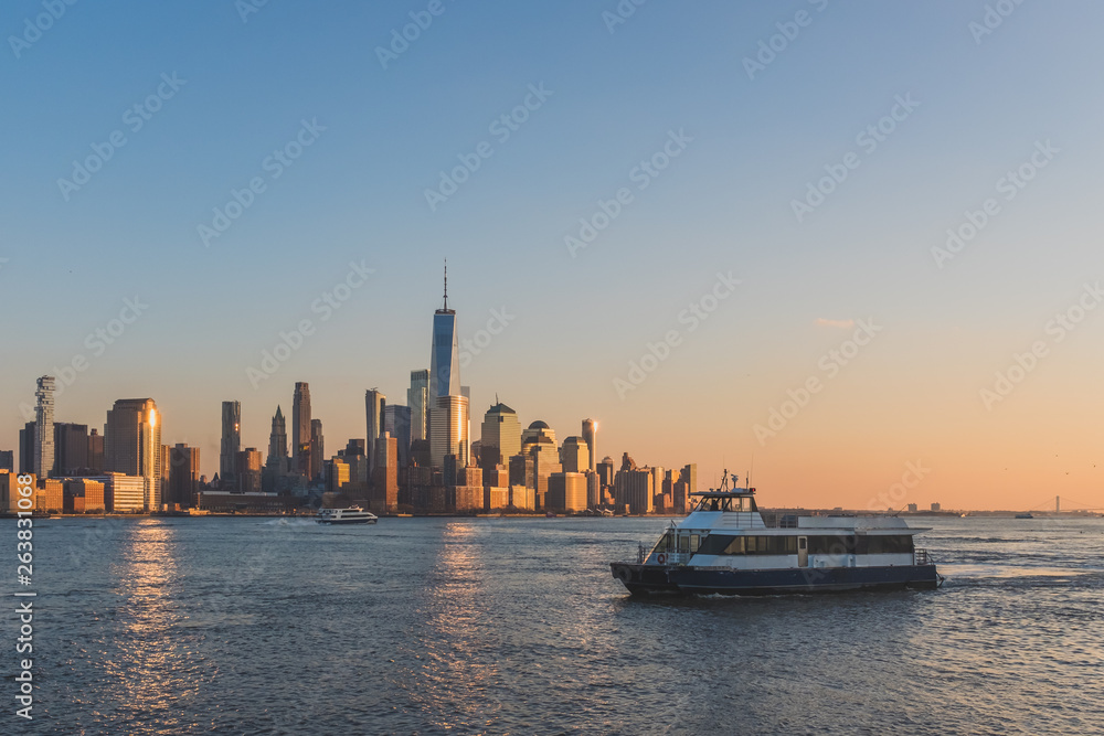 Boats traveling on Hudson River with skyline of lower Manhattan at sunset Boats traveling on Hudson River with skyline of lower Manhattan at sunset