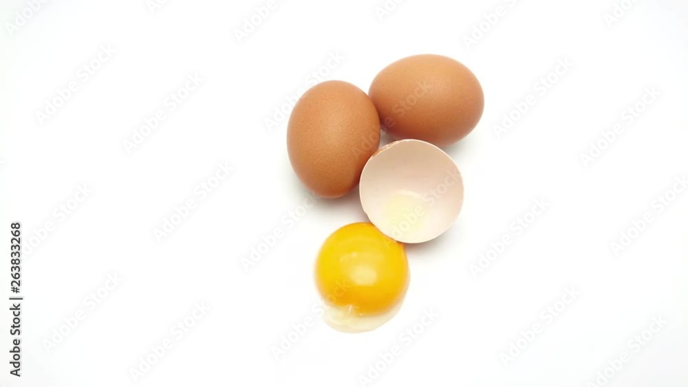 Slide shot of Whole eggs with cracked egg showing yolk isolated on white background Slide shot of Whole eggs with cracked egg showing yolk isolated on white background