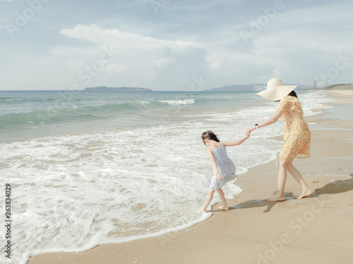 Cute toddler girl and her mother on the seaside