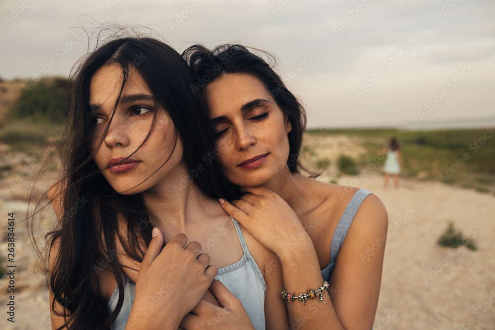 Daughter and mother embracing on beach Daughter and mother embracing on beach