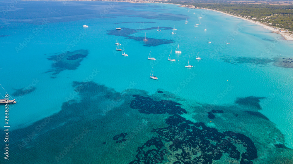 Obraz premium Amazing drone aerial landscape of the charming beach Es Trencs and the boats with a turquoise sea. It has earned the reputation of Caribbean beach of Mallorca. Spain