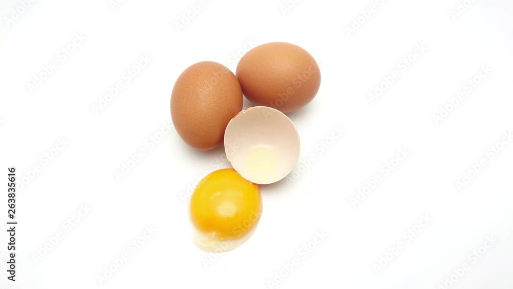 Slide shot of Whole eggs with cracked egg showing yolk isolated on white background Slide shot of Whole eggs with cracked egg showing yolk isolated on white background