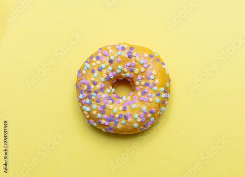 Doughnut with star shape sprinkles isolated on yellow color background