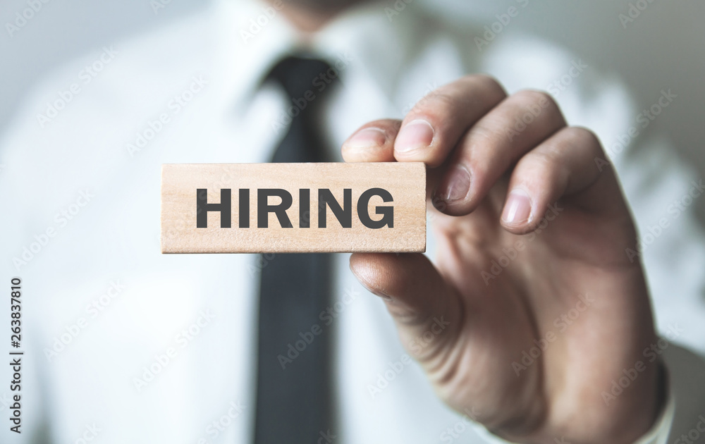 Man holding wooden block. Hiring. Business concept Man holding wooden block. Hiring. Business concept