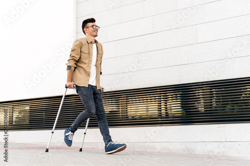 Portrait of happy young man using crutches
