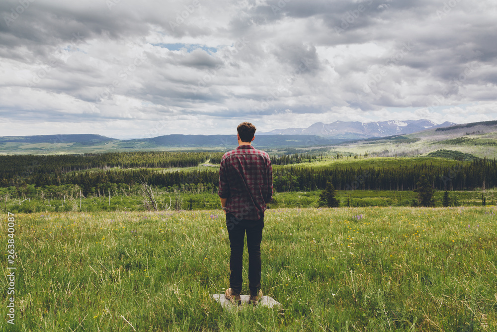 A man stands alone looking over a wide vista of American countryside A man stands alone looking over a wide vista of American countryside