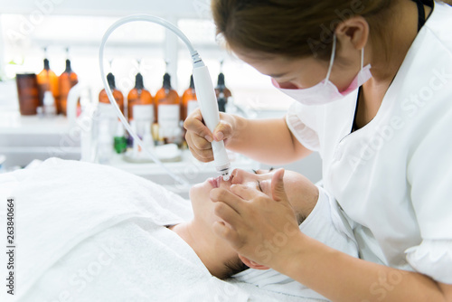 Woman receiving facial treatment in spa
