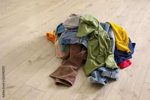 Pile of dirty laundry on wooden floor indoors