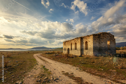 Old Eastern Orthodox church of Saint Ivan Rilski near dam Jrebchevo, Bulgaria. Ruined abandoned church at golden sunset light photo