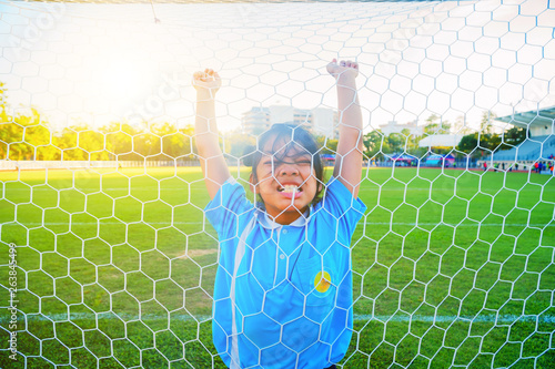 Fotografía Close-up Asian little girl who caught the eye of the white screaming fiercely on the football field, The little girl is in anger