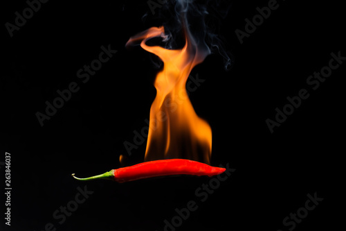 Red hot chilli with flame on a black background