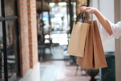 Young woman holding sale shopping bags. consumerism lifestyle concept in the shopping mall