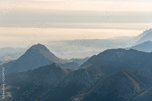 Scenic view of silhouettes of mountains in the morning mist