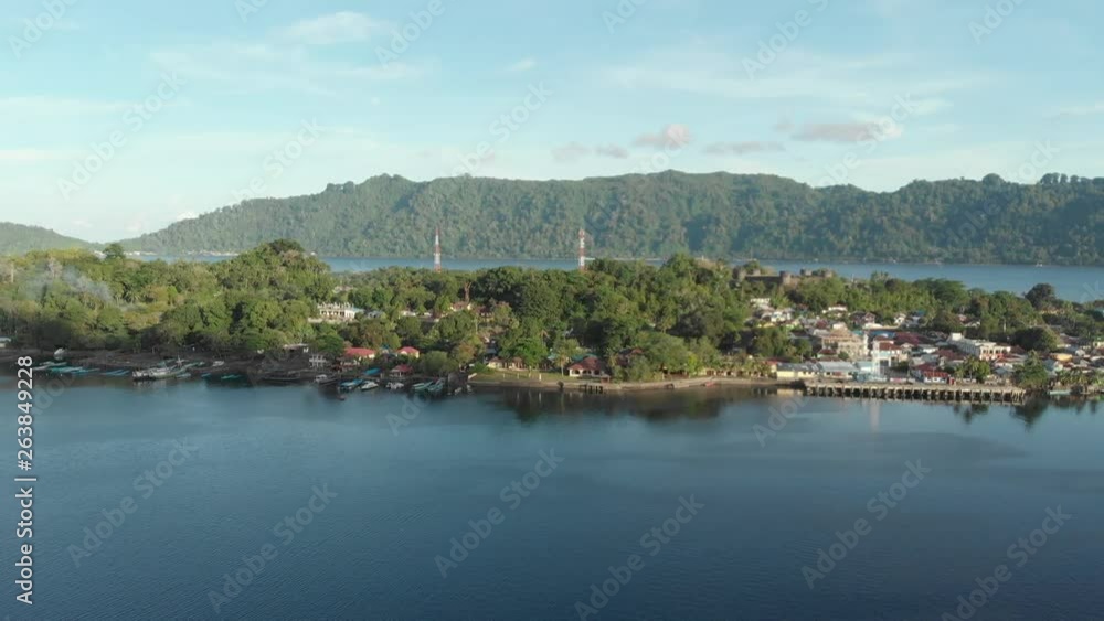 Aerial: flying over Bandaneira village at sunset Indonesia Banda Islands Pulau Naira Maluku, diving travel destination, old dutch colony for nutmeg. Native cinelike D-log color profile Aerial: flying over Bandaneira village at sunset Indonesia Banda Islands Pulau Naira Maluku, diving travel destination, old dutch colony for nutmeg. Native cinelike D-log color profile