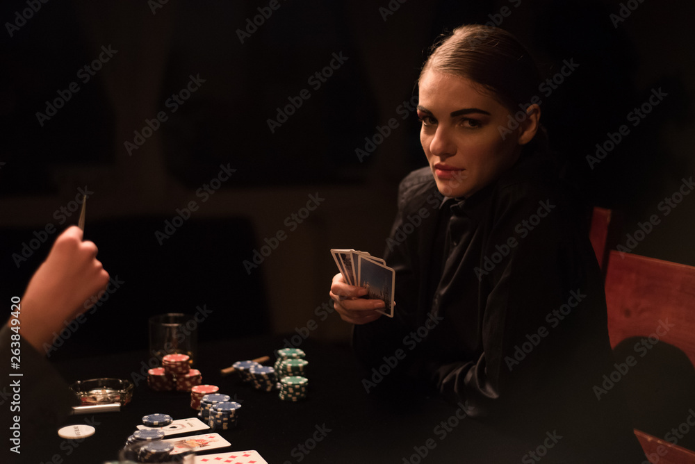 Woman playing cards at night Woman playing cards at night