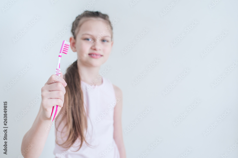 Cheerful cute girl brushes her teeth with a pink brush Cheerful cute girl brushes her teeth with a pink brush