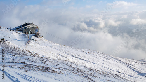 winter landscape with a house on the mountain with haze and snow