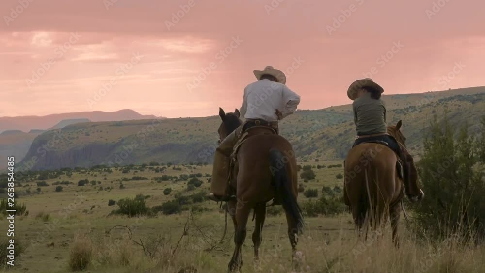 Husband and wife rest on horseback early morning while watching the storm approaching, 29 fps. Husband and wife rest on horseback early morning while watching the storm approaching, 29 fps.