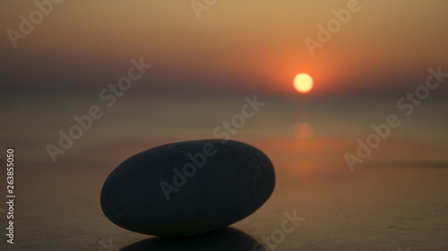 rock on the table and sunrise in the distance, at the seashore