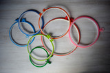 Multicolored plastic embroidery hoops for creative art on a light background. View from above.