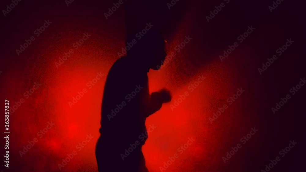 Man Air Boxing - Anger Concept - Silhouette on Red Background Man Air Boxing - Anger Concept - Silhouette on Red Background