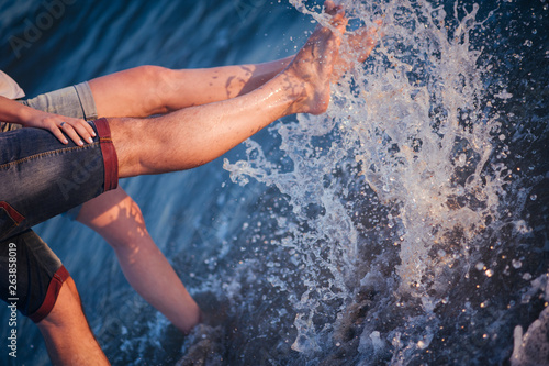 Close up of male and female legs splash in ocean water. Love near sea. Spray and drops. Emotions Summer Lifestyle People Feelings Travel Anniversary