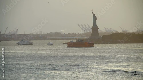 Dusk ferry passing Statue of Liberty Manhattan Bay