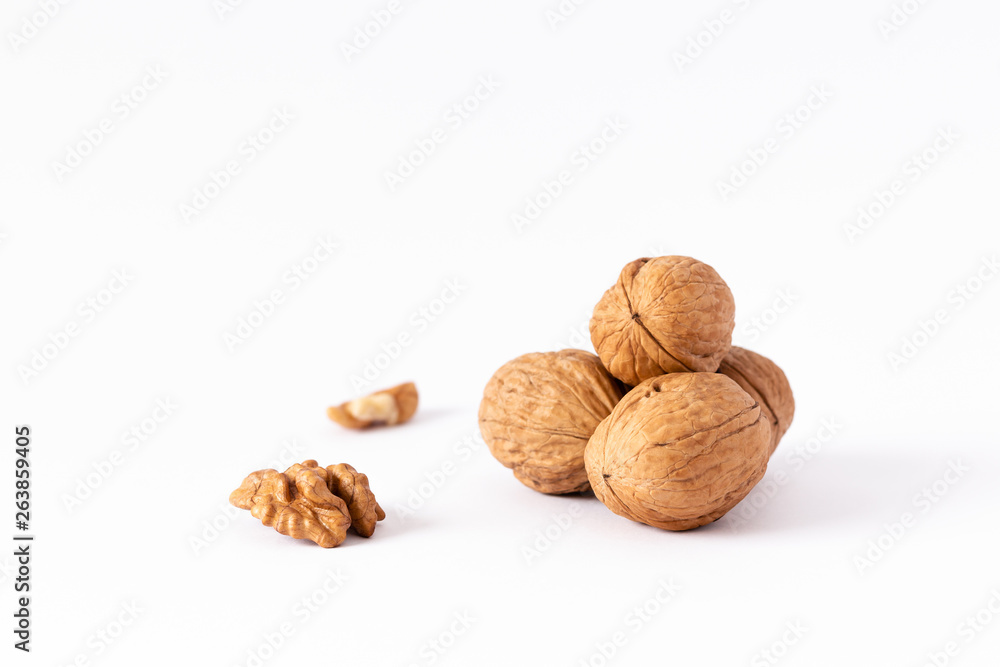 Four whole walnuts and two nutmeats isolated on white background. Four whole walnuts and two nutmeats isolated on white background.