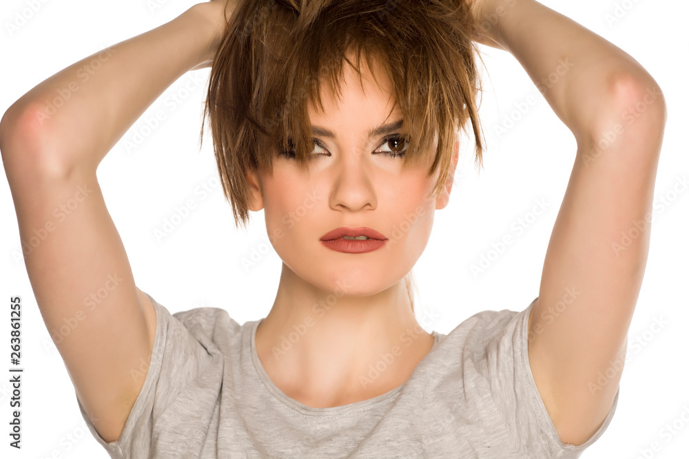 Young woman with makeup, holding her hair on white background Young woman with makeup, holding her hair on white background