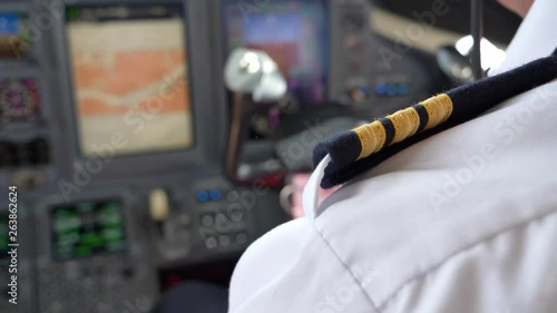 Over shoulder shot co-pilot, first officer flying in private jet aircraft, blurred instrument panel. photo