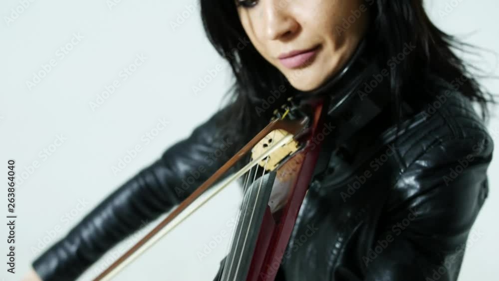 slender sensual artistic young Asian girl in tight black leather clothes expressively plays the electric violin slender sensual artistic young Asian girl in tight black leather clothes expressively plays the electric violin