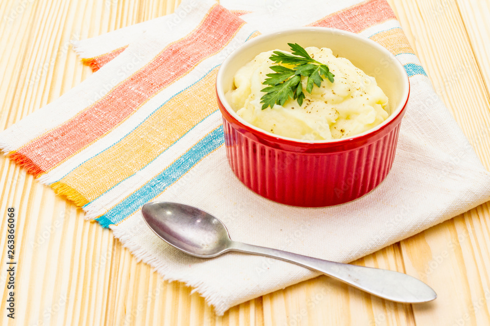 Warm mashed potatoes in a ceramic bowl with fresh parsley. On a vintage linen napkin on a stone background, close up. Warm mashed potatoes in a ceramic bowl with fresh parsley. On a vintage linen napkin on a stone background, close up.