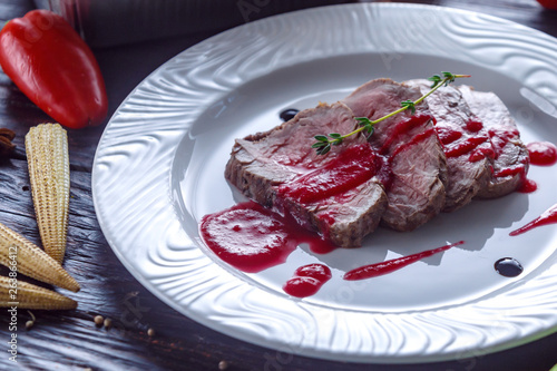 Cooked pieces of beef with cranberry sauce.