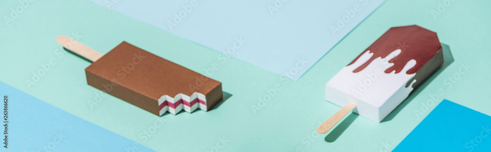 Fototapeta premium panoramic shot of handmade origami ice cream on blue and turquoise paper