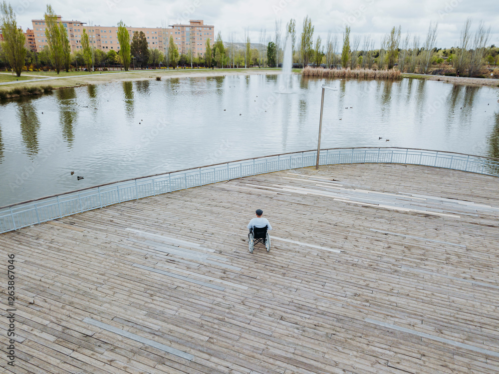 Obraz premium 43 year old male sitting on a wheelchair in the park