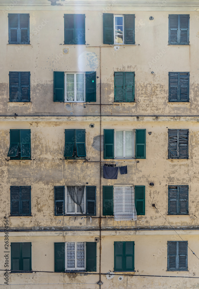 Orange wall with green windows on window Genoa, Italy