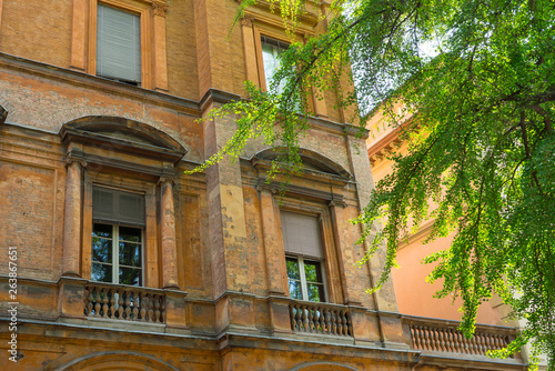 detail of orange brick building with balcony in Bologna, Italy