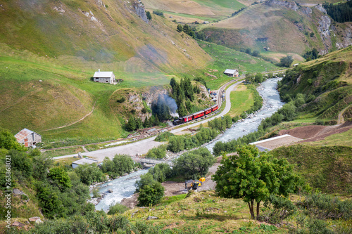 Realp, Furka - July 15, 2018: the vintage steam train going through the Raelp valley in Canton Uri, Switzerland photo