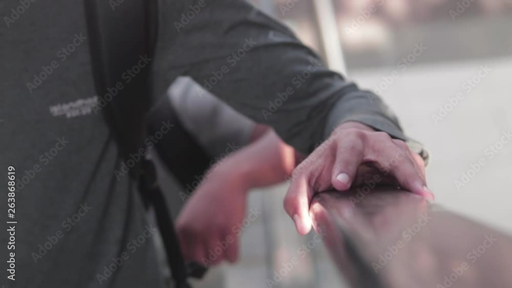 Close-up shot of a hand on an escalator handle. Close-up shot of a hand on an escalator handle.