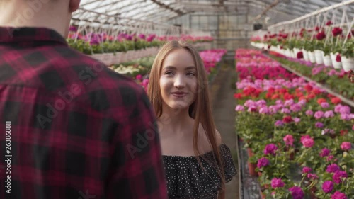 Couples- Young couples inside a greenhouse walking and its surrounded of variety of colorful flowers. photo