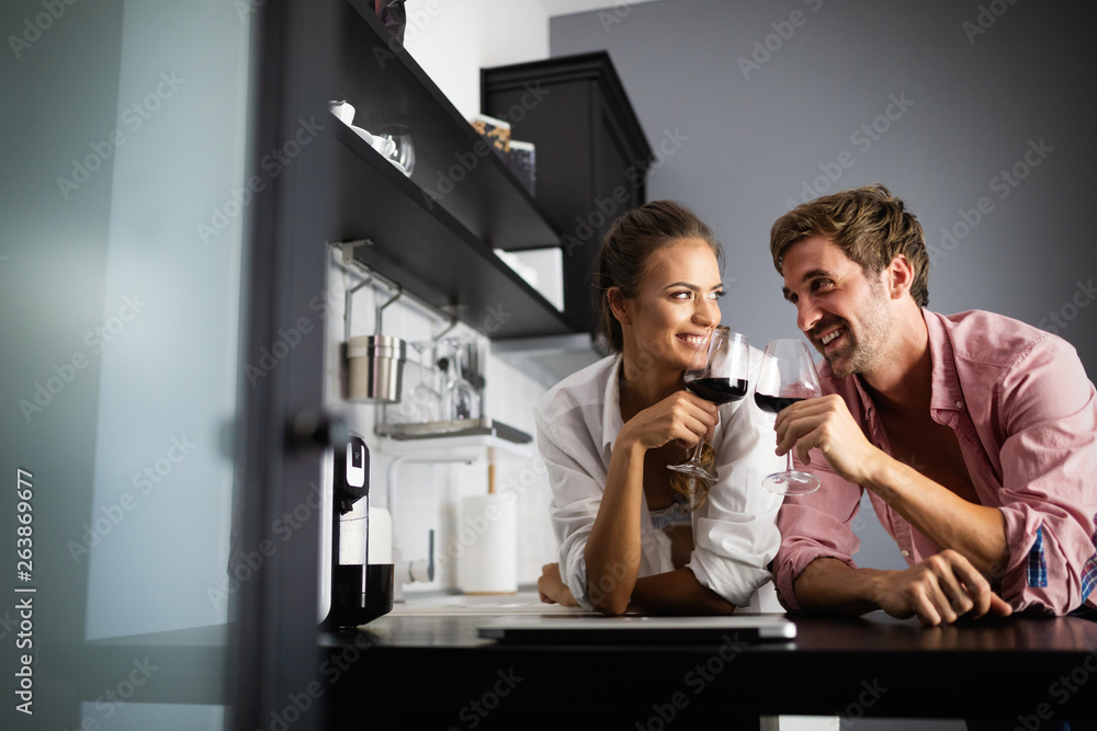 Young sexy beautiful couple cooking together and drinking wine