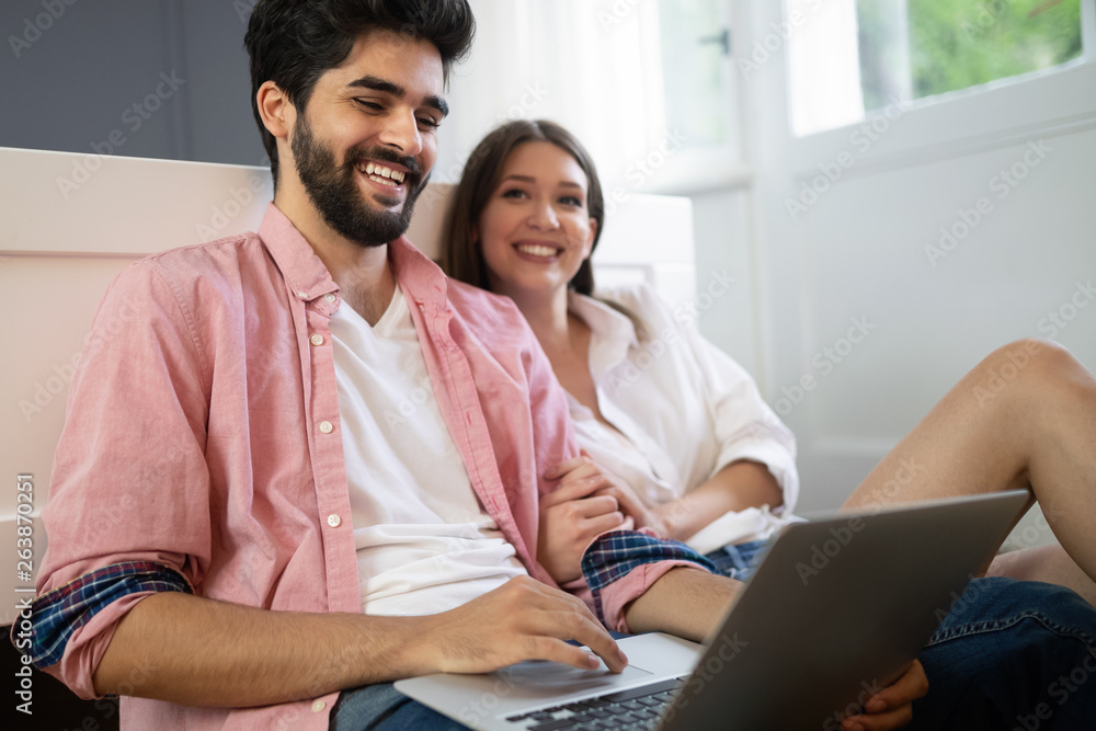 Young couple relaxing with laptop at home. Love,happiness,people and fun concept. Young couple relaxing with laptop at home. Love,happiness,people and fun concept.