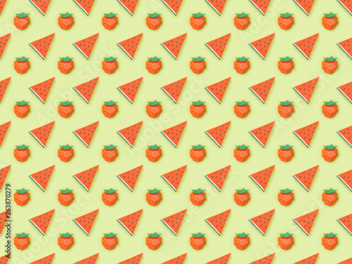 top view of textured pattern with handmade paper strawberries and watermelon slices isolated on green