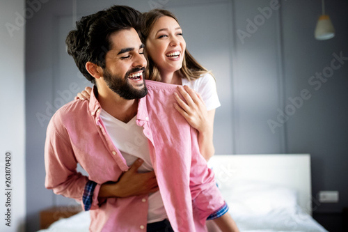 Beautiful happy couple of young lovers are hugging indoors at home, with love and tenderness